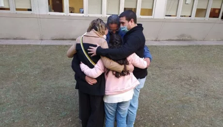 Mili, abrazando a sus padres y abuelos en la Ciudad Judicial