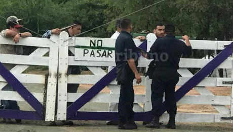 El intendente Cuenca, con policías en el portón donde comenzó la ocupación el 18 de abril de 2018.