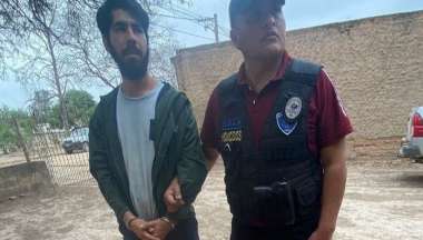 Javier y el policía que lo lleva detenido.