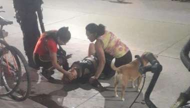 La mujer tendida en el suelo, tras ser herida de bala.